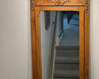 Victorian-style tall oak framed mirror featuring a decorative carved crest