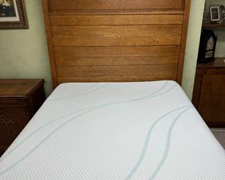 Eastlake-style oak bed frame featuring a tall headboard with carved wooden accents, newer full size mattress 