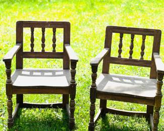 Rustic, dark-wood armchairs featuring spindle-back designs and turned leg 
