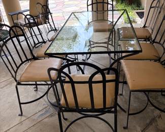 Metal and glass dining table with eight chairs. Table is 50 inches long by 30 inches deep by 29 1/2 inches high.