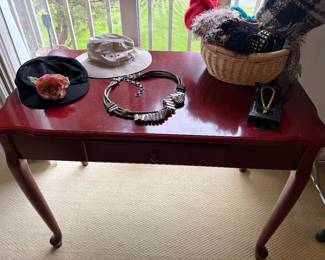 Turned-leg writing desk with center drawer with women's hats and scarves