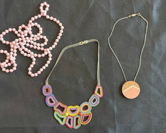 Lot 203: Assorted necklaces: pink pearl strand, colorful beaded necklace, and wood pendant necklace