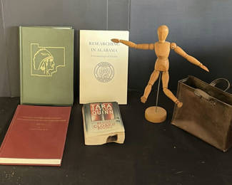 Lot 102: Assorted vintage books, a wooden mannequin, and a metal tote