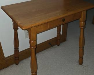 +2                   This is a rustic wooden writing desk with turned spindle legs and a single drawer.
