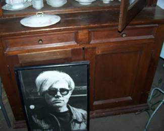ANDY WARHOL POSTER AGAINST BASE OF TWO-PIECE CUPBOARD