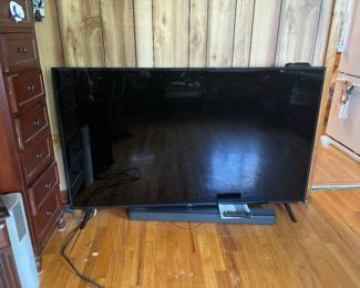 Large flatscreen, TV and cabinet full of CDs and cassettes