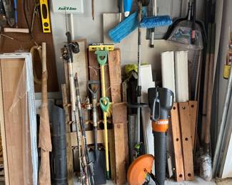 Variety of items, pieces of wood, post hole, diggers, fishing poles, shovels, and more