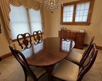 Queen Anne–style dining table with 8 matching chairs, complete with a fitted protective cover. Crystal chandelier, serving buffet table and more. 