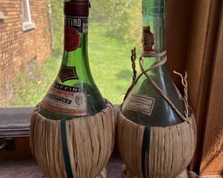 Many vintage bottles, including wine bottles with raffia basket.