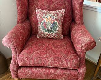wingback chair covered in red paisley fabric