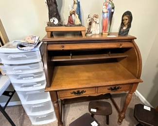 Roll top desk, religious items and stools.