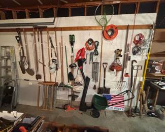 Variety of garden shovels, tools, blower, electrical cords, sledge hammers, crow bars.