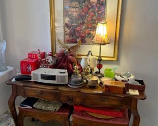 Here we have a framed artwork, a Bose wave radio, and the table with two matching cushioned seats.