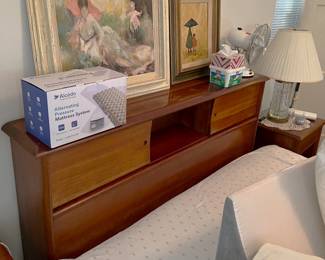 Here we have the very useful headboard with sliding doors in front of the cubby holes.  Oh, and notice the two framed art works on top.