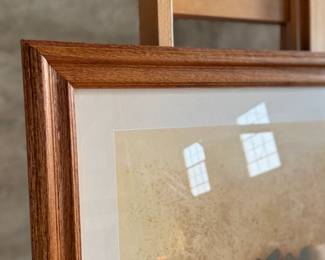 "Mujer Con Metate", a professionally framed print by listed artist, G.E. Mullan circa 1980s. Professionally framed and measures in frame, 28.5” H x 33.5” W.