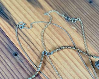 This lot features three (3) sterling silver necklaces with pieces including jade, pearls, and more. Total approx. weight of 46.91 grams.