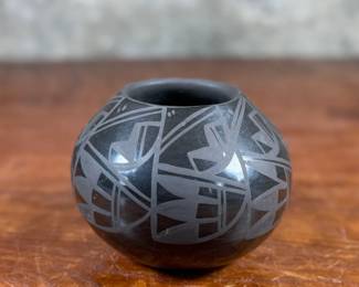 This lot features a beautiful vase by listed artist, Birdell Bourdon circa 1992. Signed underneath as shown in photos and measures, 4” H. Birdell Bourdon ("Vine Flower") is a renowned Santa Clara Pueblo potter from New Mexico, specializing in hand-coiled, deep-carved, and polished blackware. Active since the 1980s, her work is known for high-gloss and traditional styles.