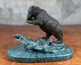 This lot features a bronze bear sculpture on a stone plinth by SPI Gallery. Signed as shown in photos and measures, 7” H x 10” W x 5” D.