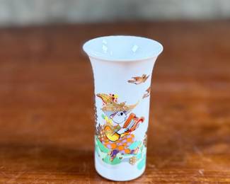 This lot features a vintage 1970s porcelain vase designed by Bjørn Wiinblad for Rosenthal Studio-Linie, featuring a whimsical colorful illustration of a harp player. Measures, 4” H and comes in excellent condition.
