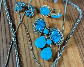 This lot features a large collection of turquoise jewelry that appears to be primarily faux stones. There are twelve (12) pieces in total including four (4) pairs of earrings, three (3) pendants, one (1) brooch, and one (1) parure set.