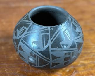 This lot features a beautiful vase by listed artist, Birdell Bourdon circa 1992. Signed underneath as shown in photos and measures, 4” H. Birdell Bourdon ("Vine Flower") is a renowned Santa Clara Pueblo potter from New Mexico, specializing in hand-coiled, deep-carved, and polished blackware. Active since the 1980s, her work is known for high-gloss and traditional styles.