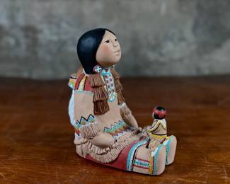 This lot features an Indian storyteller sculpture by listed artist, Cleo Teissedre circa 1990s. This sculpture measures, 6.5” H.