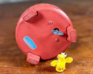 This lot features a 1976 Gorham Sesame Street Big Bird and Little Bird music box. The music box features Big Bird standing next to a “Sesame Street” signpost. It operates using a magnet mechanism that makes the small bird dance on the brick-patterned base. It was produced by the Gift World of Gorham and is in working condition.