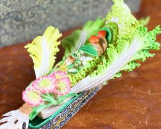 This lot features a Chinese carved and painted vegetable sculpture featuring bok choy, grasshopper, flowers, and more. Carved out of bone, quite delicate and will not be shipped in house.