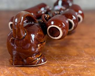 This lot features a vintage dachshund-shaped ceramic decanter set, often referred to as a "drunken dog" liquor flask set. In excellent condition and measures, 5” H x 13” W x 7” D.
