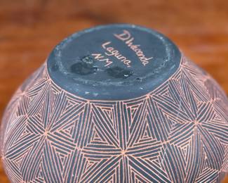 This lot features a stunning pottery vessel by listed artist, Debra Waconda. Signed underneath as shown in photos and measures, 5” H. Debra Waconda is a renowned Acoma Pueblo artist known for hand-coiling, painting, and signing fine-line black-on-white pottery, frequently featuring geometric patterns and intricate designs, with active pieces dating from the 1990s and 2000s. Her work, along with other Acoma potters such as Elizabeth Waconda, is considered authentic Native American Pueblo art.