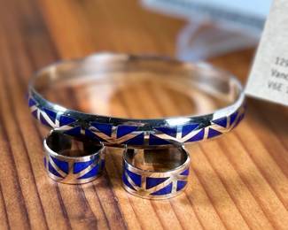 This lot features a set of handcrafted sterling silver & lapis lazuli inlay jewelry including a bracelet and a pair of earrings. Originally purchased from Lapis Box in Vancouver, BC with the original box and papers.