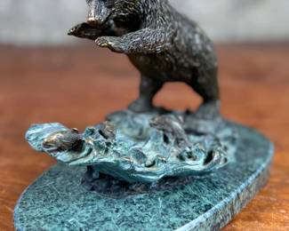This lot features a bronze bear sculpture on a stone plinth by SPI Gallery. Signed as shown in photos and measures, 7” H x 10” W x 5” D.