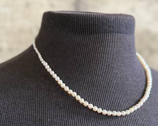 This lot features a stunning Art Deco genuine pearl necklace with a dual-clasp featuring a ruby and genuine diamonds. This necklace measures, 20” with a total approx. weight of 13.81 grams.