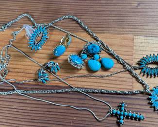 This lot features a large collection of turquoise jewelry that appears to be primarily faux stones. There are twelve (12) pieces in total including four (4) pairs of earrings, three (3) pendants, one (1) brooch, and one (1) parure set.