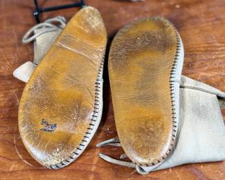 This lot features a pair of what appear to be antique Native American moccasins, consistent with styles produced in the 19th century by Plains tribes.