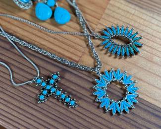 This lot features a large collection of turquoise jewelry that appears to be primarily faux stones. There are twelve (12) pieces in total including four (4) pairs of earrings, three (3) pendants, one (1) brooch, and one (1) parure set.