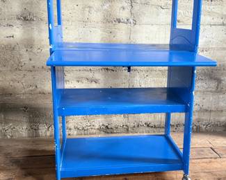 This lot features a two (2) piece wooden book or bar cart on casters with a fold down shelf. This cabinet measures, 65” H x 29.5” W x 19.5” D. Small crack that could be repaired on a caster as shown in photos.