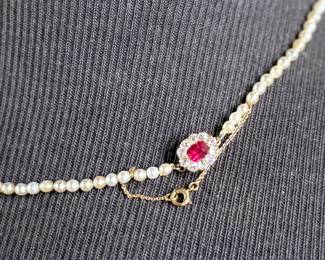 This lot features a stunning Art Deco genuine pearl necklace with a dual-clasp featuring a ruby and genuine diamonds. This necklace measures, 20” with a total approx. weight of 13.81 grams.