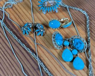 This lot features a large collection of turquoise jewelry that appears to be primarily faux stones. There are twelve (12) pieces in total including four (4) pairs of earrings, three (3) pendants, one (1) brooch, and one (1) parure set.
