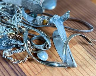 This lot features a large collection of sterling silver jewelry and scrap with a total approx. weight of 256.44 grams.