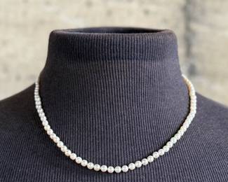 This lot features a stunning Art Deco genuine pearl necklace with a dual-clasp featuring a ruby and genuine diamonds. This necklace measures, 20” with a total approx. weight of 13.81 grams.