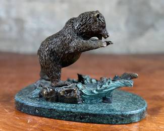 This lot features a bronze bear sculpture on a stone plinth by SPI Gallery. Signed as shown in photos and measures, 7” H x 10” W x 5” D.