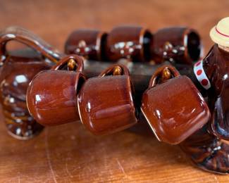 This lot features a vintage dachshund-shaped ceramic decanter set, often referred to as a "drunken dog" liquor flask set. In excellent condition and measures, 5” H x 13” W x 7” D.