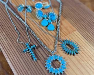 This lot features a large collection of turquoise jewelry that appears to be primarily faux stones. There are twelve (12) pieces in total including four (4) pairs of earrings, three (3) pendants, one (1) brooch, and one (1) parure set.