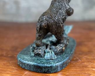 This lot features a bronze bear sculpture on a stone plinth by SPI Gallery. Signed as shown in photos and measures, 7” H x 10” W x 5” D.