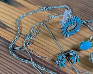 This lot features a large collection of turquoise jewelry that appears to be primarily faux stones. There are twelve (12) pieces in total including four (4) pairs of earrings, three (3) pendants, one (1) brooch, and one (1) parure set.