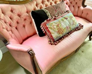 19th-century Victorian style settee upholstered in pink with a carved mahogany wood frame