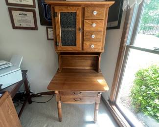 Hoosier-style cabinet, likely dating from the 1920s to the early 1930s, featuring specialized storage for kitchen items and a pull-out work surface. Possum Belly Drawer