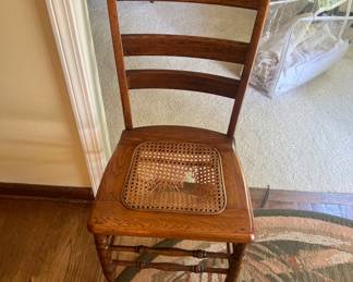 vintage Victorian-style ladderback side chair with a handwoven cane seat and turned wooden legs.