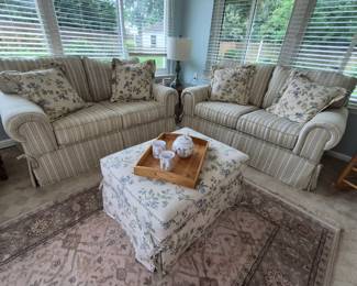 Pair of upholstered loveseats and ottoma in sunroom